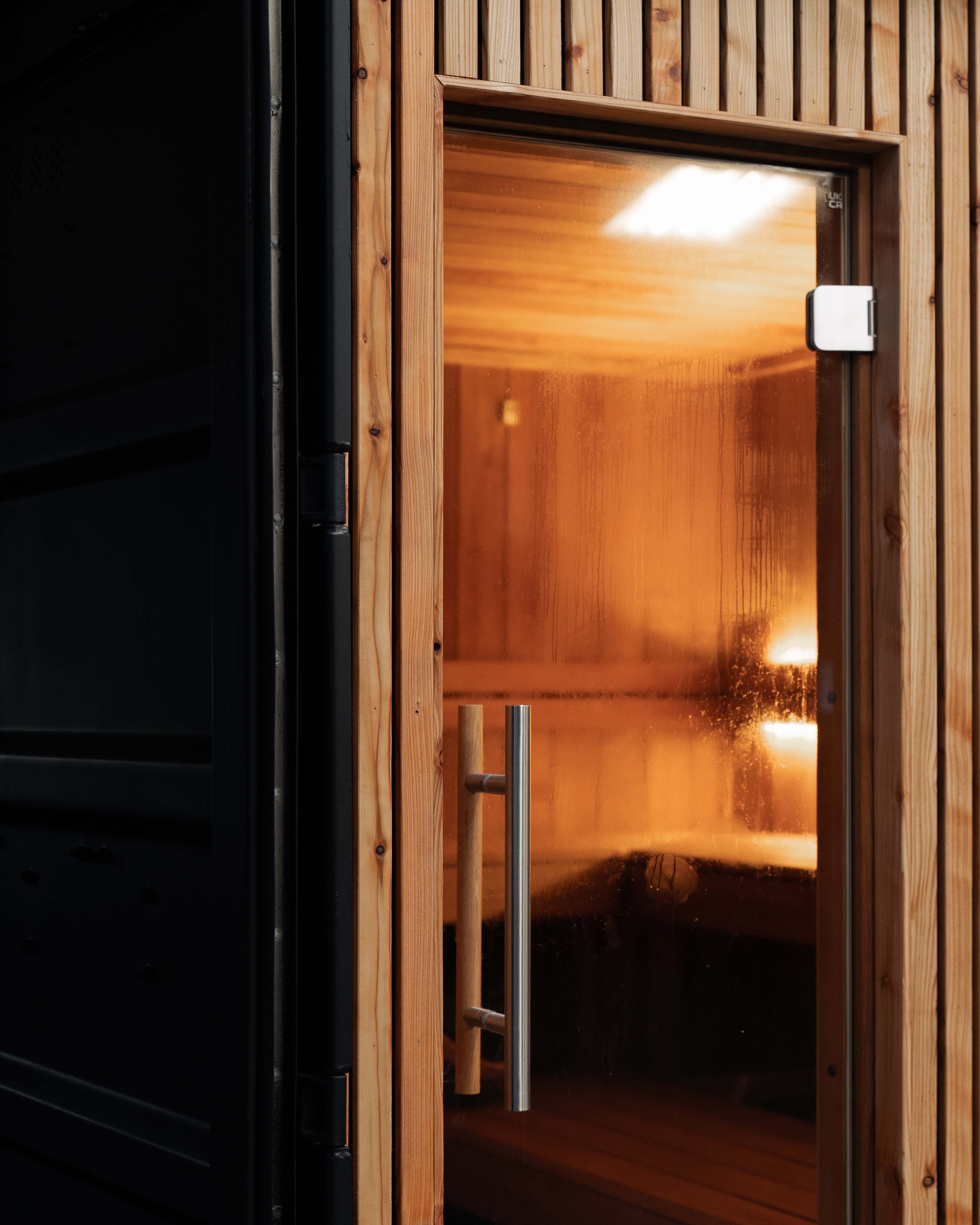 Container sauna door, timber frame with glass panel