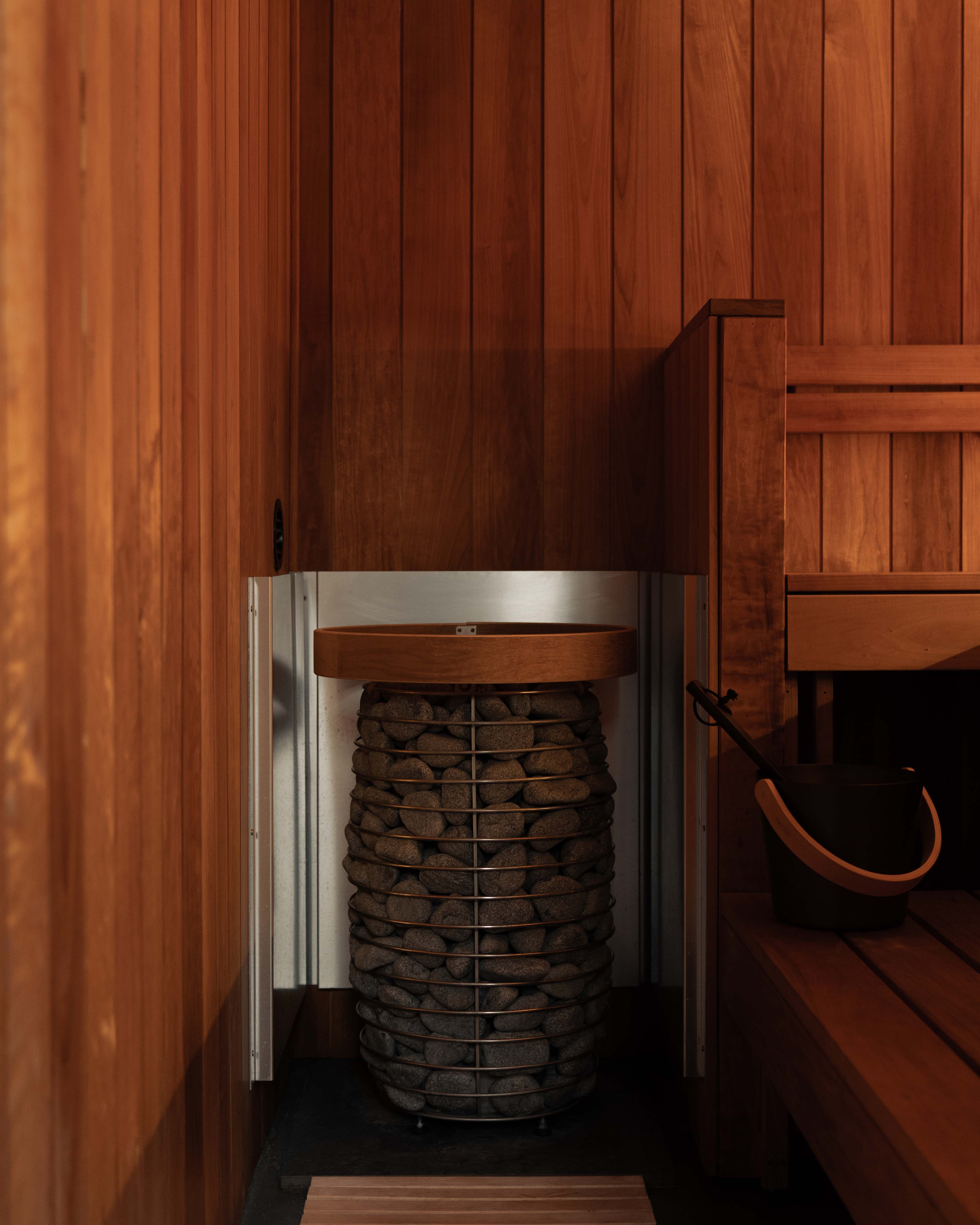 Electric sauna heater loaded with stones inside a container sauna